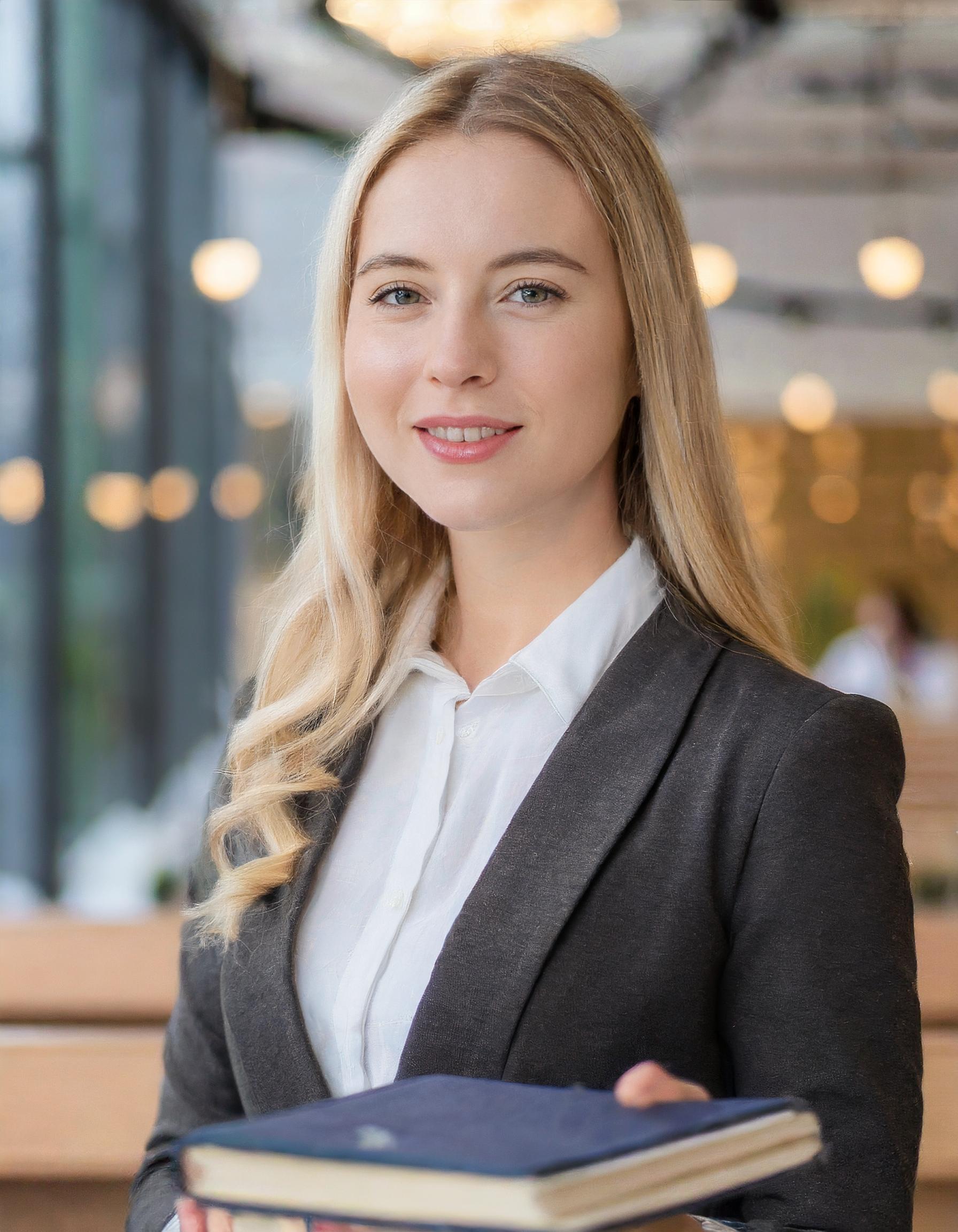 Junge Frau in einem klassischen Business-Outfit mit einem sympathischen Lächeln